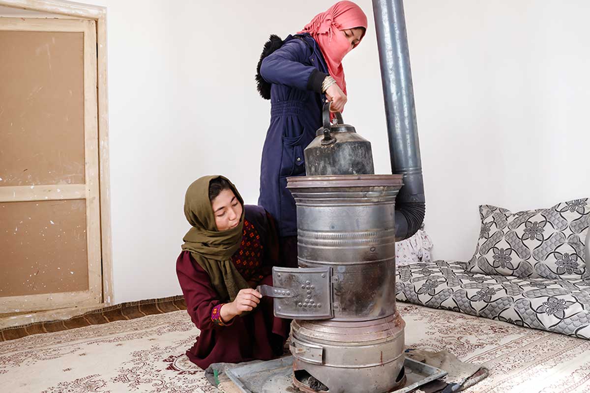 Two women using a UNHCR bukhary heading device