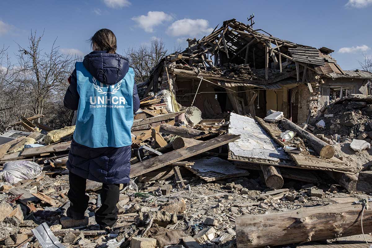 A volunteer standing on the rubble of a collapsed house