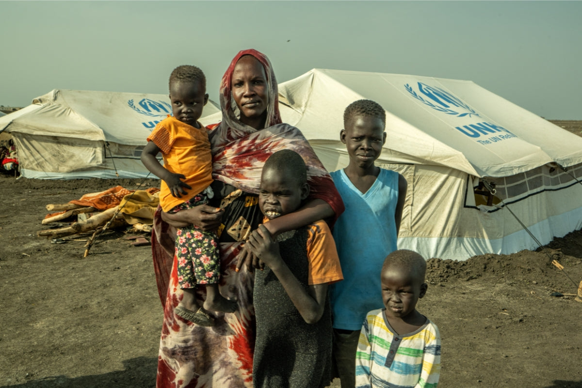 Family in front of UNHCR tent in Sudan